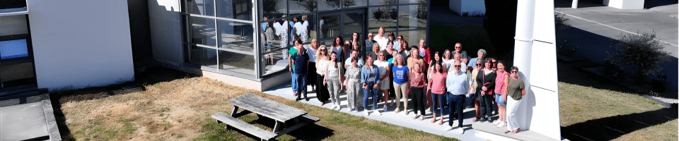 Groupe de personnes en extérieur au soleil devant le bâtiment du Service de Formation Continue